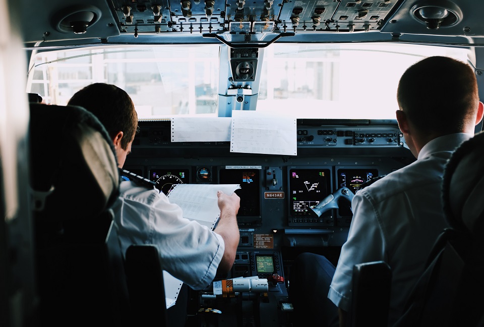 two pilots in cockpit checking paperwork