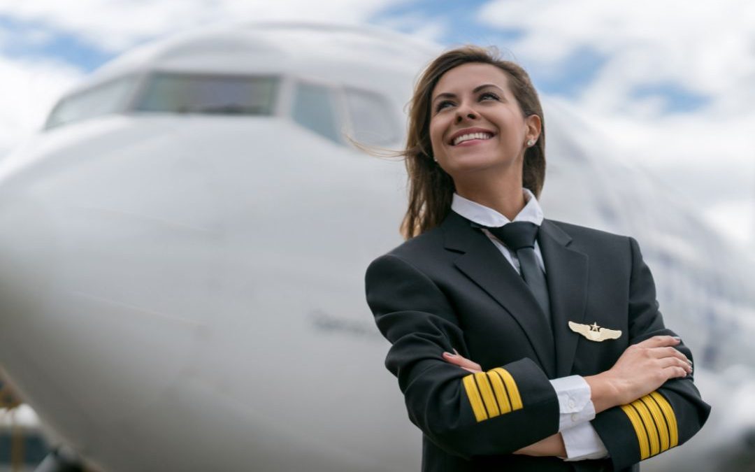 female pilot in uniform in front of plane