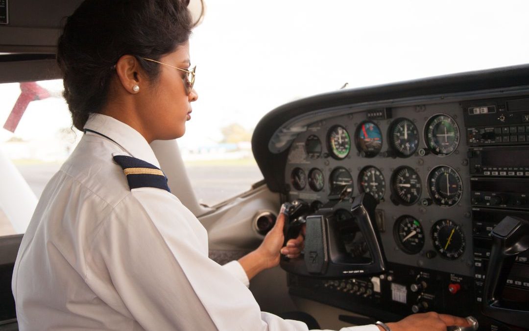 female pilot in cockpit wearing uniform